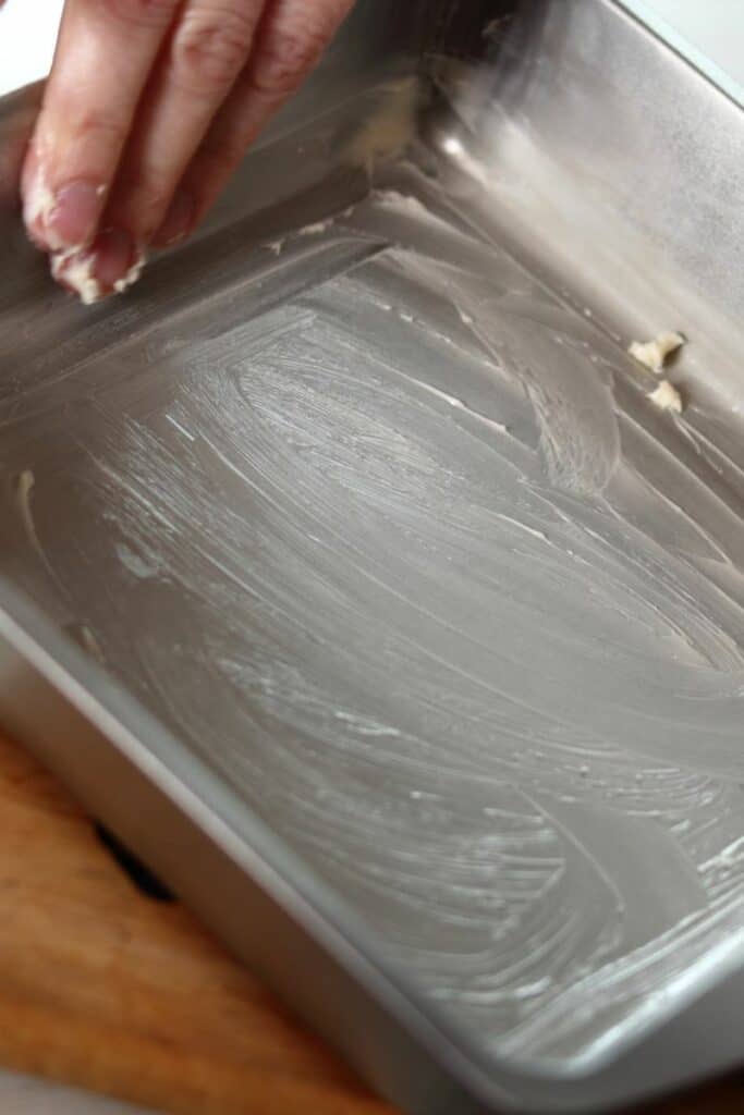 Buttering a baking pan with hand
