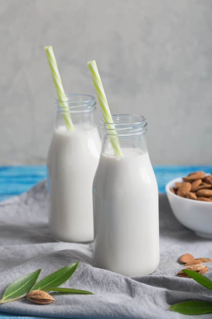 Almond milk in two glasses with green straws