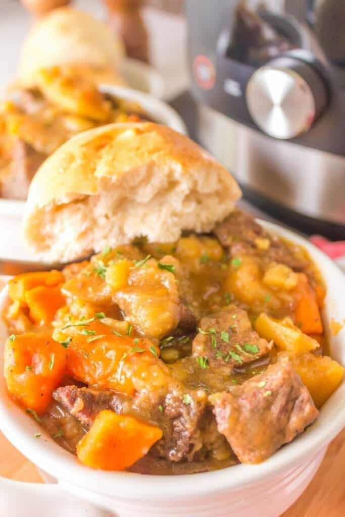 Thawed beef stew with a biscuit broken in half on top