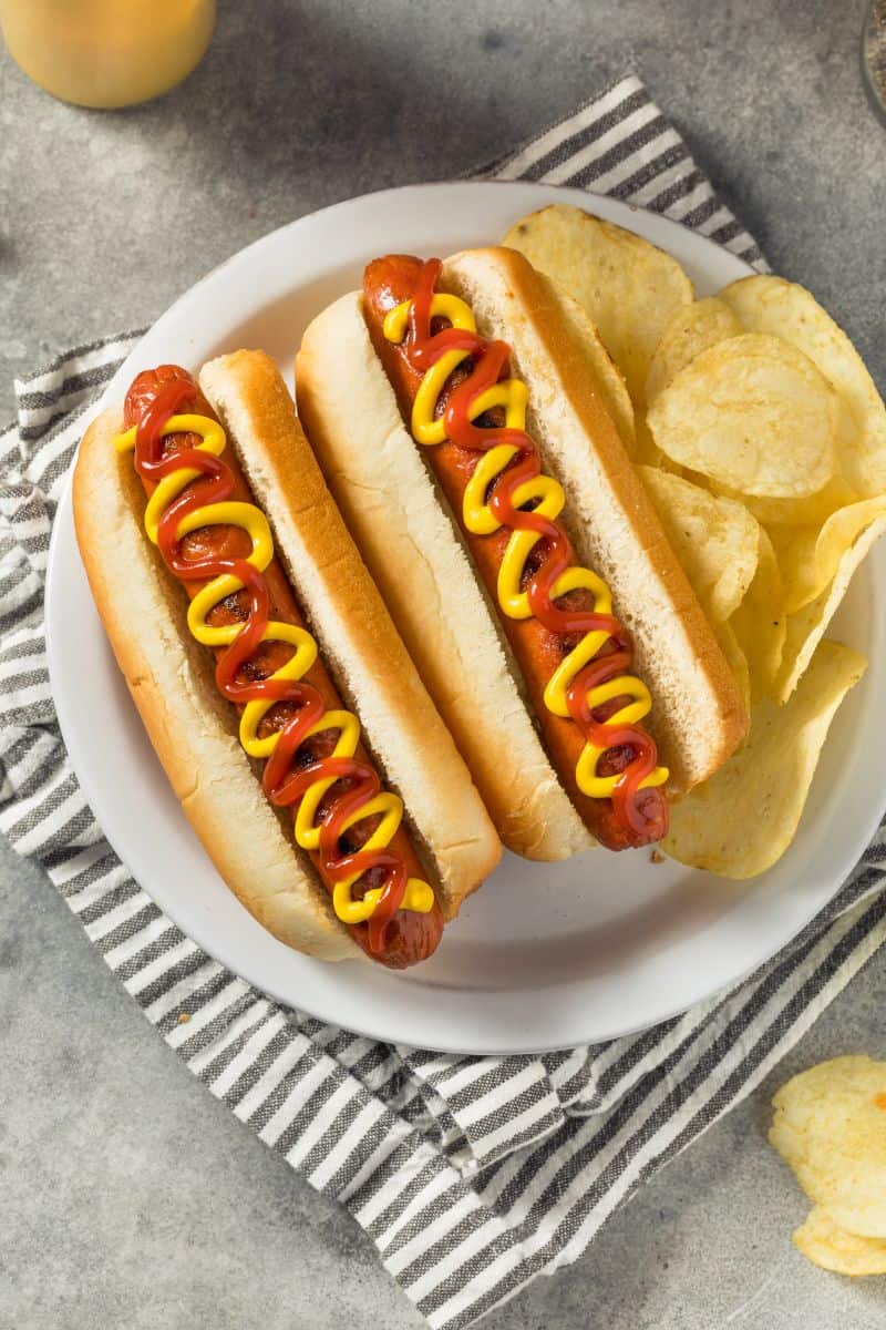 hot dogs with ketchup and mustard in a bun on a plate